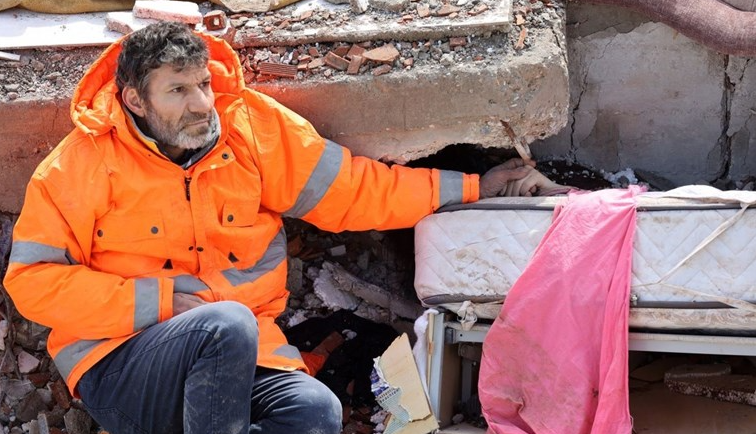 Потресна фотографија: Татко ја држи раката на својата мртва ќерка затрупана под урнатините во Турција
